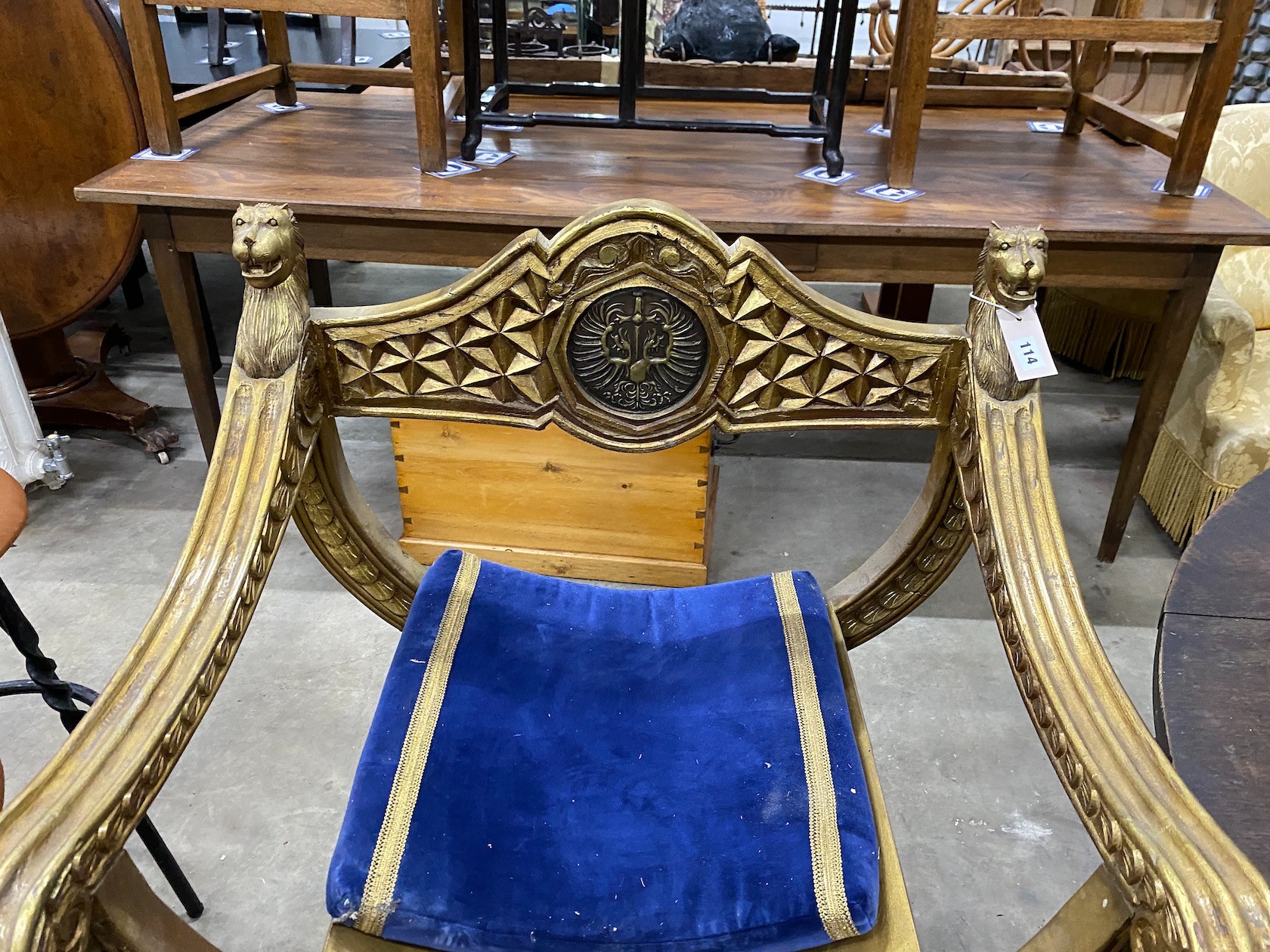 A classical style gilt x-frame elbow chair, width 73cm, depth 52cm, height 96cm and a matching footstool